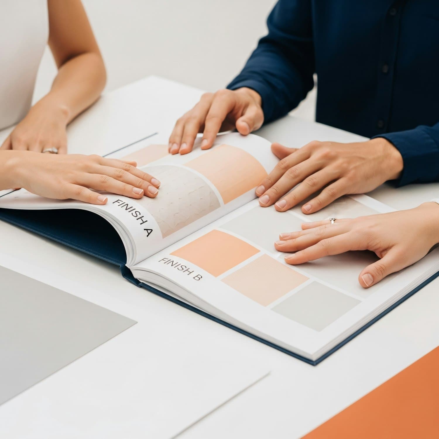 Three of the team going through a book of paper and colour samples on the worktable